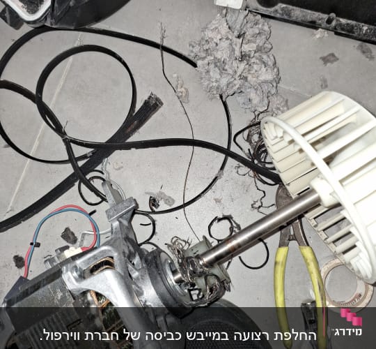 מנוע חשמלי מפורק עם חוטים וכלים על הרצפה